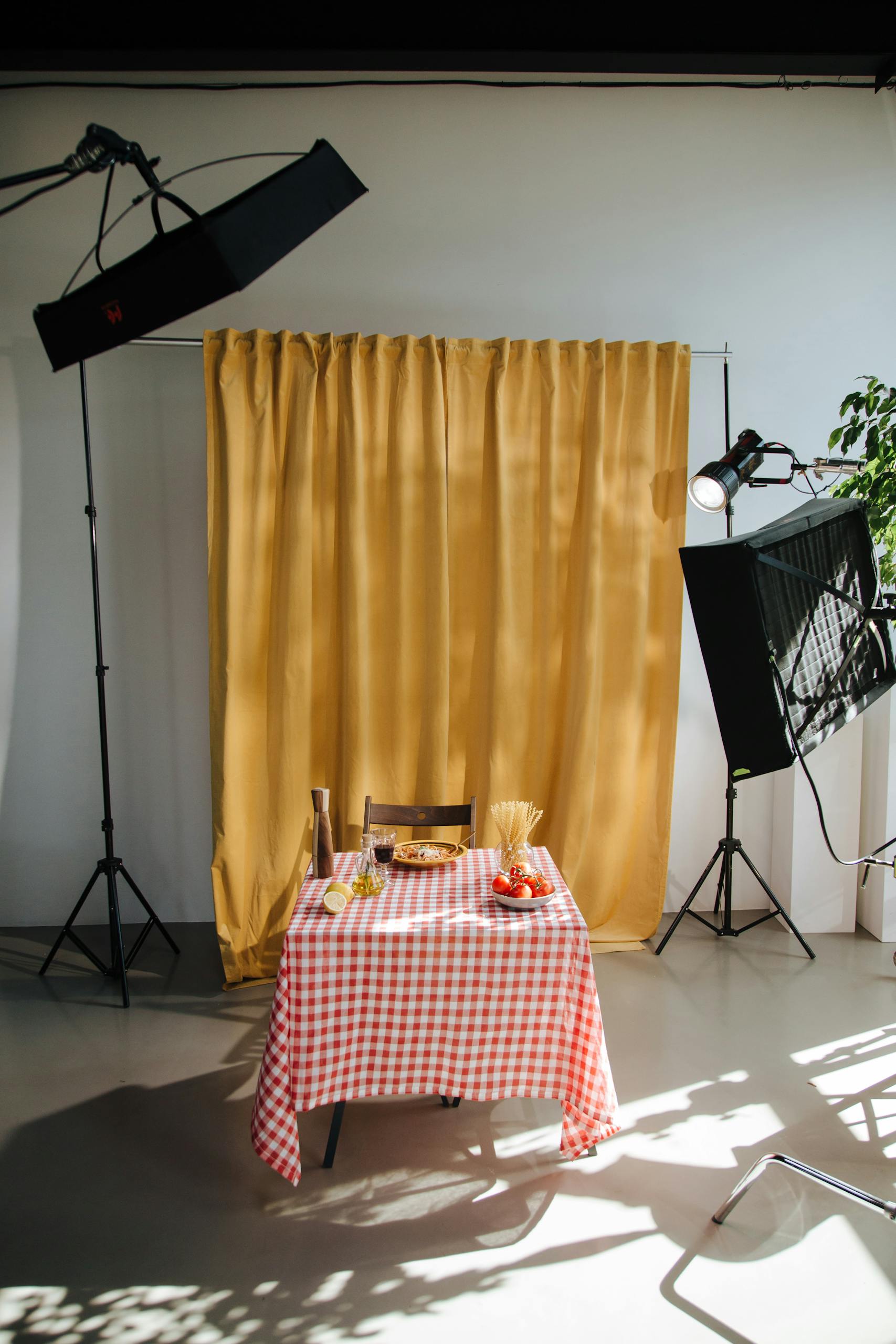 Photo studio setup featuring a table with food against a yellow curtain backdrop.