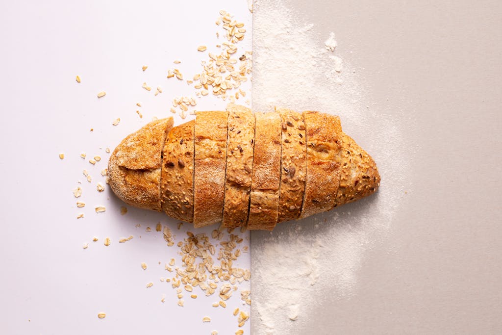 Freshly sliced whole grain bread with oats and flour provides a rustic and nutritious appeal.